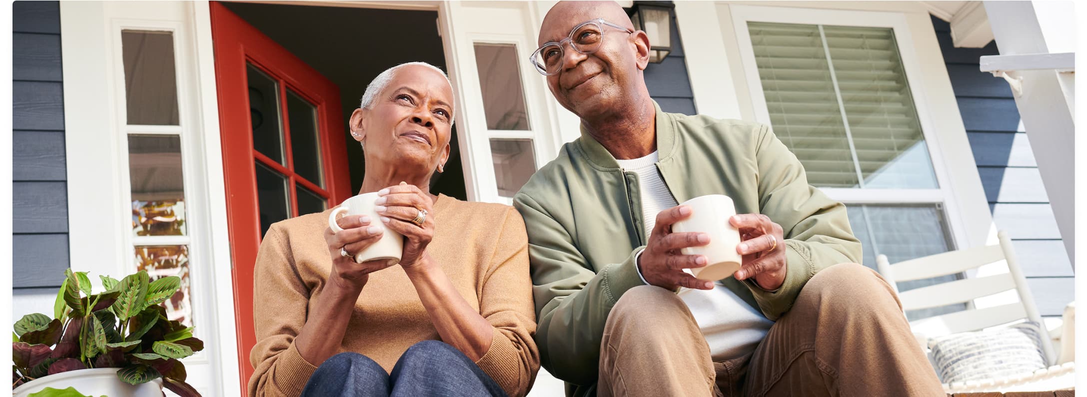 couple enjoying coffee on the front porch of their home clad in hardie plank in deep ocean