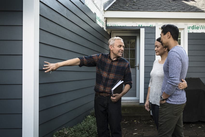 Contractor talking to homeowner about siding exterior Contractor talking to homeowner about siding exterior